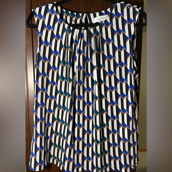 Sleeveless blouse with open pleats at neck and a small button on the back. - Picture 1 of 6